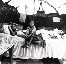 Unemployed family in their 'house' in KTC squatter camp, Cape Town; their shack was destroyed by ...