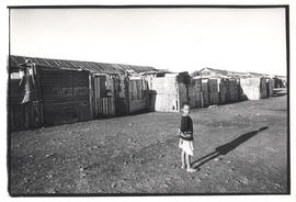 Child in front of row of shacks in Red Location, KwaNdebele