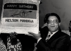 Dr. Allan Boesak holds aloft a birthday cake for jailed ANC leader Nelson Mandela's 70th birthday...