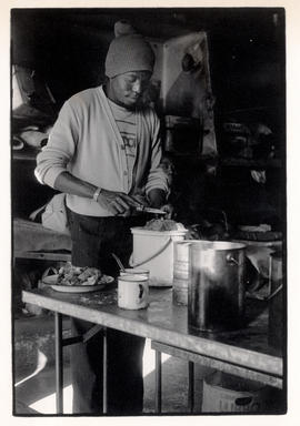 Man preparing food in gold mine hostel