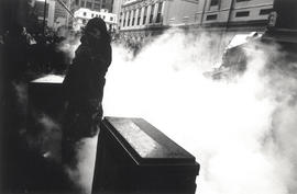 Young black woman tries to protect herself against the police teargas in Burg Street, Cape Town