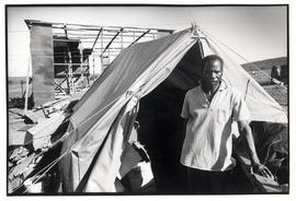 Man builds a house behind a government issued tent in which he lives in KwaNdebele