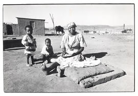 Woman with two toddlers sitting outside in Umbulwane near Ladysmith, Natal - threatened with forc...