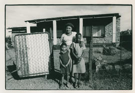 A Magopa woman and children in front of a house before being forcefully removed
