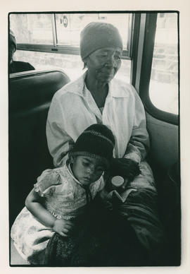 A Magopa woman and child on a bus, being forcefully removed