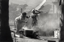 Two black women at work outside their houses in Alexandra township