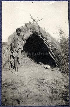 A woman building a thatched hut