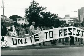 Students holding a banner printed "unite to resist".