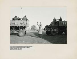 A lone woman protests as soldiers occupying the township roll by in large armoured vehicles known...