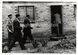 Sobukwe entering his home in Mofolo, Soweto with security police
