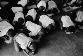 Students kneel on the floor