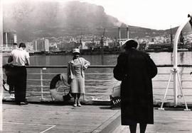 People on board a ship taking photos against Table Mountain