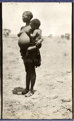 A woman carrying her child, who is feeding at her breast, Nossop