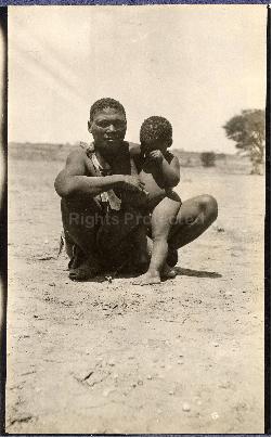 A bushman child sitting with an adult, Nossop